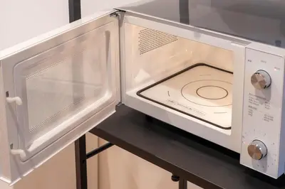 a microwave oven with its door open on a table at \u5343\u5c0b 130t in Tokyo