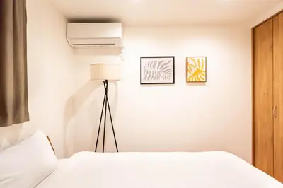 a bedroom with a white bed and a fan at \u5343\u5c0b 130t in Tokyo