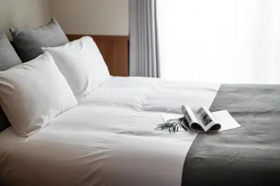 a bed with two books on it with a window at \u30e2\u30f3 \u30b7\u30e3\u30c8\u30fc\u4e2d\u91ce\u54f2\u5b66\u5802 in Tokyo