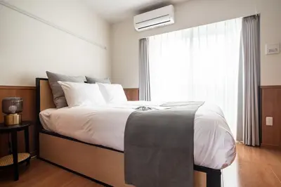 a bedroom with a large bed and a window at \u30e2\u30f3 \u30b7\u30e3\u30c8\u30fc\u4e2d\u91ce\u54f2\u5b66\u5802 in Tokyo