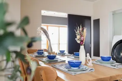 a wooden table with blue dishes and a vase of flowers at Maison Nagasaki Five 3F MN3 in Tokyo