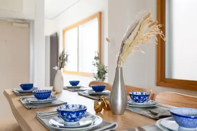 a wooden table with blue and white bowls and a vase at Maison Nagasaki Five 3F MN3 in Tokyo