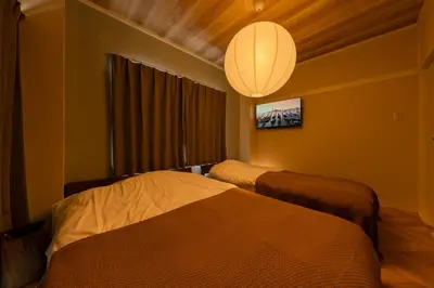 a hotel room with two beds and a chandelier at Maison Nagasaki Five 4F MN4 in Tokyo