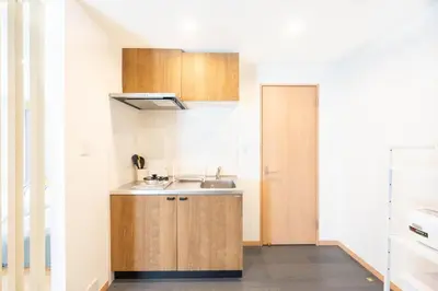a small kitchen with wooden cabinets and a sink at \u5922\u306e\u5bbf \u685c\u96c51F 131Ta in Tokyo