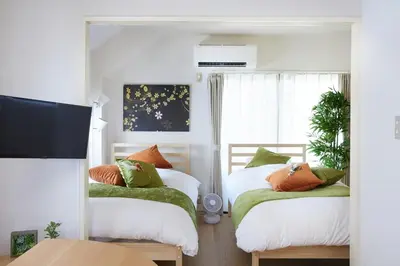 a bedroom with two beds and a window at K&H立石5丁目m305 in Tokyo