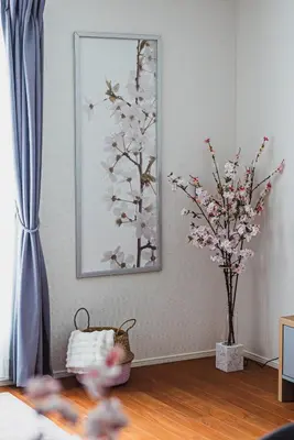 a living room with a mirror and a vase with flowers at Hotel Shunkashuto Sakura 1 min to station in Tokyo