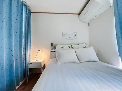 a bedroom with a bed with a blue curtain at Ikebukuro\u99c5\u304b\u3089\u5f92\u6b698\u5206\u6700\u59278\u4eba\u6728\u6728\u65e7\u9928 in Tokyo