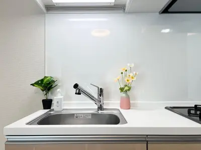 a kitchen sink with flowers in a vase at nestay apartment tokyo skytree in Tokyo