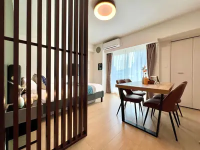 a room with a table and chairs and a bedroom at nestay apartment tokyo skytree in Tokyo