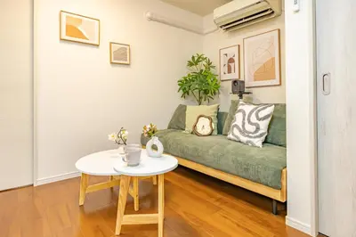 a living room with a green couch and a table at Asakusa Cozy Japanese House with Tatami & Projector, 5min to Station in Tokyo