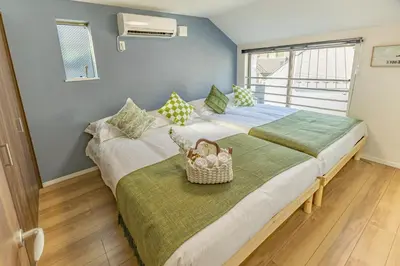 two beds in a bedroom with a basket on the bed at 7 min walk from JR Yamanote Line Uguisudani Spacious 4-Bedroom House near Ueno & Asakusa With Parking in Tokyo