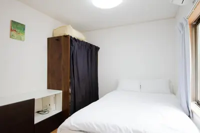 a small bedroom with a bed and a window at SunRise STAY Minamidai\u4e2d\u91ce\u5357\u53f0 in Tokyo