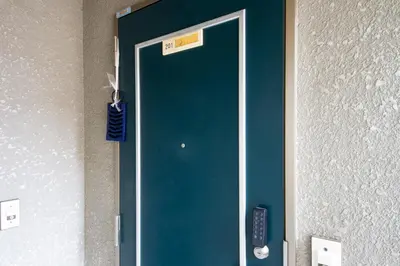 a blue door in a room with a remote control at SunRise STAY Minamidai\u4e2d\u91ce\u5357\u53f0 in Tokyo