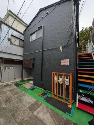 a black house with orange gates in front of it at SunRise STAY Minamidai\u4e2d\u91ce\u5357\u53f0 in Tokyo