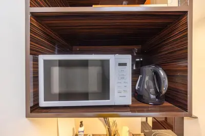 a microwave oven sitting on top of a shelf at 101 Direct to Narita Haneda 5-minute walk from Keikyu Kamata Station, with kitchen, ideal for telework, apartment in Tokyo