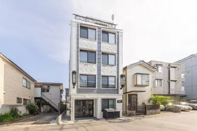 a tall white building on a city street at 101 Direct to Narita Haneda 5-minute walk from Keikyu Kamata Station, with kitchen, ideal for telework, apartment in Tokyo