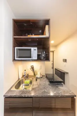 a kitchen with a sink and a microwave at 201 Direct access to Narita Haneda 5-minute walk to Keikyu Kamata Station, with kitchen, ideal for telework, apartment in Tokyo