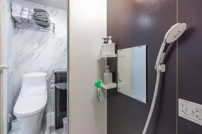 a small bathroom with a toilet and a mirror at 201 Direct access to Narita Haneda 5-minute walk to Keikyu Kamata Station, with kitchen, ideal for telework, apartment in Tokyo