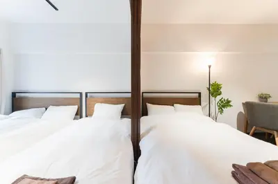 two beds with white sheets in a room at Shibuya E-address 205 in Tokyo