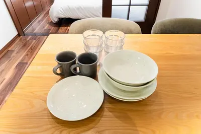 a table with plates and cups on a wooden table at Shibuya E-address 205 in Tokyo