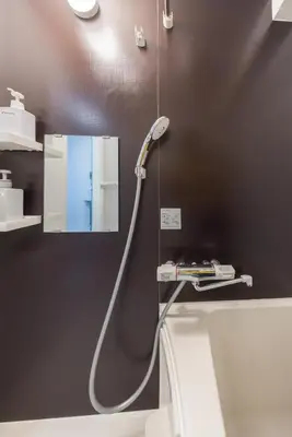 a shower with a hose attached to a wall at 401 Direct to Narita Haneda 5-minute walk from Keikyu Kamata Station with kitchen, ideal for telework, apartment in Tokyo