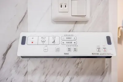 a white remote control on a white marble wall at 401 Direct to Narita Haneda 5-minute walk from Keikyu Kamata Station with kitchen, ideal for telework, apartment in Tokyo