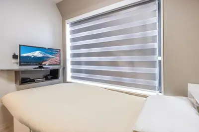 a bedroom with a window with a view of a mountain at 402 Direct access to Narita Haneda 5-minute walk from Keikyu Kamata Station with kitchen, ideal for telework, apartment in Tokyo