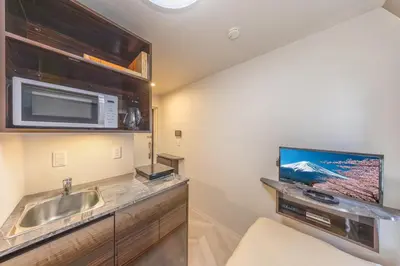 a kitchen with a sink and a microwave at 402 Direct access to Narita Haneda 5-minute walk from Keikyu Kamata Station with kitchen, ideal for telework, apartment in Tokyo