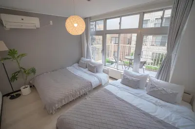 two beds in a room with a large window at 3 minutes to Shinjuku by subway-Nakanokaikan III in Tokyo