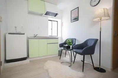 a kitchen with two chairs and a table and a lamp at 3 minutes to Shinjuku by subway-Nakanokaikan III in Tokyo