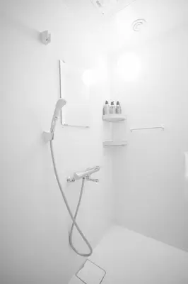 a shower with a hose in a white bathroom at 3 minutes to Shinjuku by subway-Nakanokaikan III in Tokyo