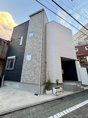 a brick building with a door and two potted plants at Entire house, 3 minutes on foot from Ekoda station, 2 stations by train to Harry Potter, direct access to Ikebukuro,Shinjuku,Shibuya,Roppongi in Tokyo