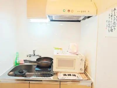 a small kitchen with a sink and a microwave at Pearl Heights 102 Traditional Japanese-style private apartment for 1-4 people, close to Ikebukuro Shinjuku business district in Tokyo