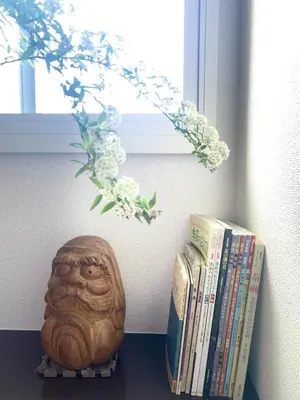 a shelf with two books and a statue next to a window at Pearl Heights 301 suit room, Easy access to Ikebukuro Shinjuku Station in Tokyo