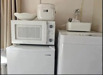 a microwave sitting on top of two refrigerators at Pearl Heights 201 Easy access to Ikebukuro Shinjuku, Cozy 1 room in Tokyo