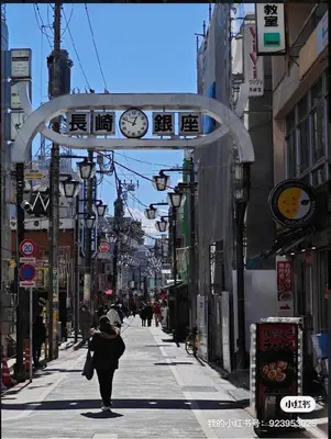 a woman walking down a city street with a clock on a building at Pearl Heights 201 Easy access to Ikebukuro Shinjuku, Cozy 1 room in Tokyo