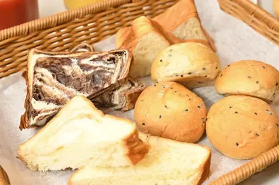 a basket filled with bread and buns on a table at Sanco Inn Grande Tokyo Hamamatsucho in Tokyo