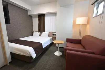 a hotel room with a bed and a couch at Sanco Inn Grande Tokyo Hamamatsucho in Tokyo