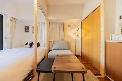 a small bedroom with a bed and a wooden table at Shinjuku 10 min walk, Higashi Shinjuku 4 min, Kabukicho, Shin-Okubo apartment in Tokyo
