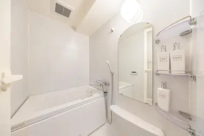 a white bathroom with a tub and a mirror at Shinjuku 10 min walk, Higashi Shinjuku 4 min, Kabukicho, Shin-Okubo apartment in Tokyo