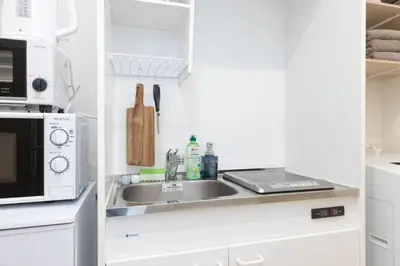 a kitchen with a sink and a microwave at \u30e1\u30eb\u30c7\u30a3\u30a2\u6771\u5800\u5207 in Tokyo