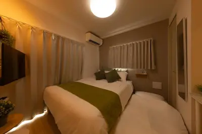 a bedroom with a bed and a television in it at \u30e1\u30eb\u30c7\u30a3\u30a2\u6771\u5800\u5207 in Tokyo
