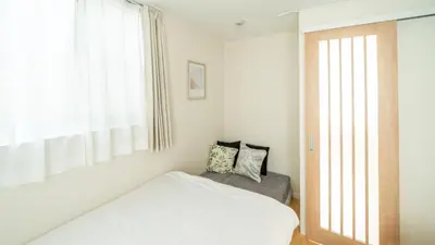 a small bedroom with a bed and a window at \u3055\u304f\u3089\u65c5\u9928\u9ad8\u5186\u5bfa\u5317\u5343\u5229\u4f11101\u53f7\u5ba4 in Tokyo