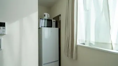 a small refrigerator in a room with a window at \u3055\u304f\u3089\u65c5\u9928\u9ad8\u5186\u5bfa\u5317\u5343\u5229\u4f11101\u53f7\u5ba4 in Tokyo