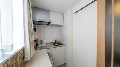 a small kitchen with white cabinets and a sink at \u3055\u304f\u3089\u65c5\u9928\u9ad8\u5186\u5bfa\u5317\u5343\u5229\u4f11101\u53f7\u5ba4 in Tokyo
