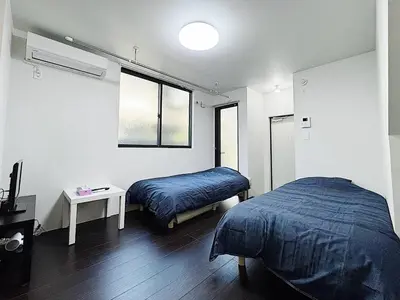 a bedroom with two beds and a table and a window at Tokyo Stay Top Ikebukuro #103 in Tokyo