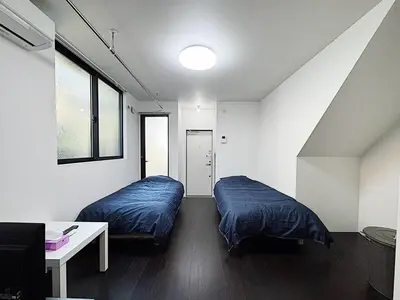 a bedroom with two beds and a table and a window at Tokyo Stay Top Ikebukuro #103 in Tokyo