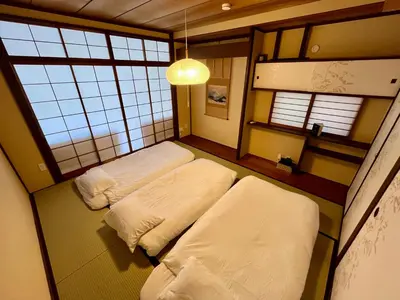 two beds in a room with two windows at GU Hotel Traditional Japanese-Style House in Tokyo15 Minutes by Train from Shinjuku Sleeps Up to 10 Guests in Tokyo