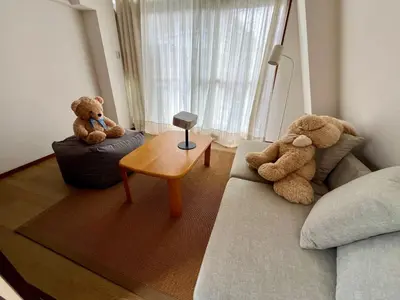 two teddy bears sitting on a couch in a living room at GU Hotel Traditional Japanese-Style House in Tokyo15 Minutes by Train from Shinjuku Sleeps Up to 10 Guests in Tokyo