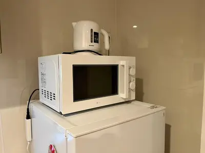 a microwave sitting on top of a refrigerator at GU Hotel Traditional Japanese-Style House in Tokyo15 Minutes by Train from Shinjuku Sleeps Up to 10 Guests in Tokyo